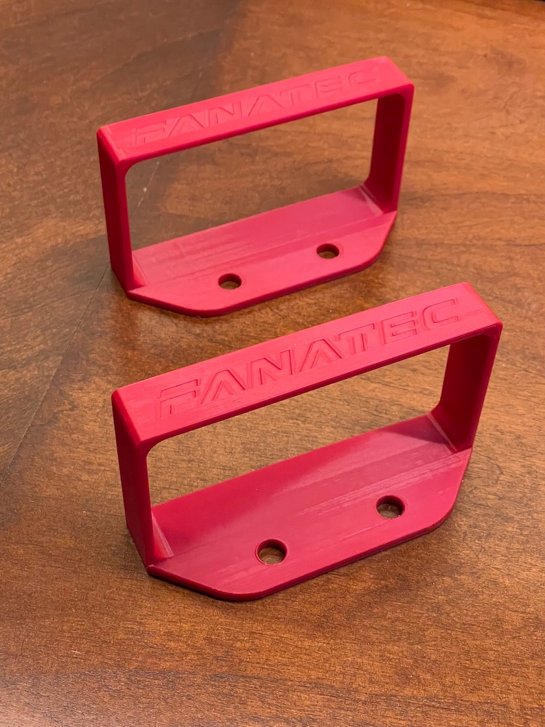 May include: Two red plastic Fanatec mounting brackets with three holes each.