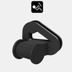 Op de afbeelding: Zwarte autogordelgesp met een cilindrische basis en een gebogen handvat. De gesp heeft een eenvoudig, geometrisch ontwerp en is gemaakt van een solide, mat materiaal. Een klein, zwart vierkant pictogram staat in de linkerbovenhoek.