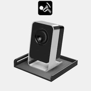 Puede incluir: Un altavoz negro con una base plateada se encuentra sobre una bandeja negra. El altavoz tiene una rejilla de altavoz redonda negra.