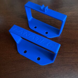 May include: Two blue plastic wall mounts with holes for screws. The bottom mount has the word "FANATEC" printed on it.