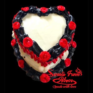 K&ouml;nnte beinhalten: Ein herzf&ouml;rmiger Kuchen, der mit schwarzem und rotem Frosting verziert ist. Der Kuchen ist mit roten Rosen verziert und die Worte "Sweets From Above" und "Made with love" stehen unten.