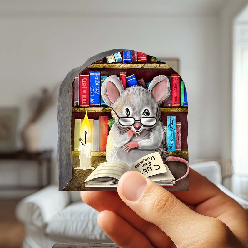 Puede incluir: Un rat&oacute;n gris con gafas est&aacute; sentado en un entorno de biblioteca, leyendo un libro titulado "Cats for Dummies". El rat&oacute;n est&aacute; rodeado de estanter&iacute;as llenas de libros, incluyendo "Of Mice and Men" y "Tom & Jerry". Una vela encendida se encuentra en la mesa junto al rat&oacute;n.