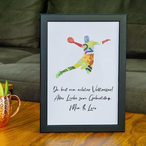 Könnte beinhalten: Ein gerahmter Druck mit einer bunten Silhouette eines Volleyballspielers. Der Text lautet "Du bist ein echter Volltreffer! Alles Liebe zum Geburtstag. Mia & Louis."
