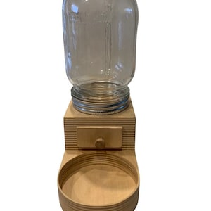 Peut inclure: Un distributeur de nourriture pour animaux en bois avec un bocal en verre pour la nourriture s&egrave;che et un bol pour l'eau. Le distributeur a un petit tiroir pour ranger les friandises.