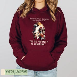 a woman wearing a maroon hoodie with an american flag on it