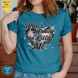 a woman wearing a blue t - shirt with a heart on it