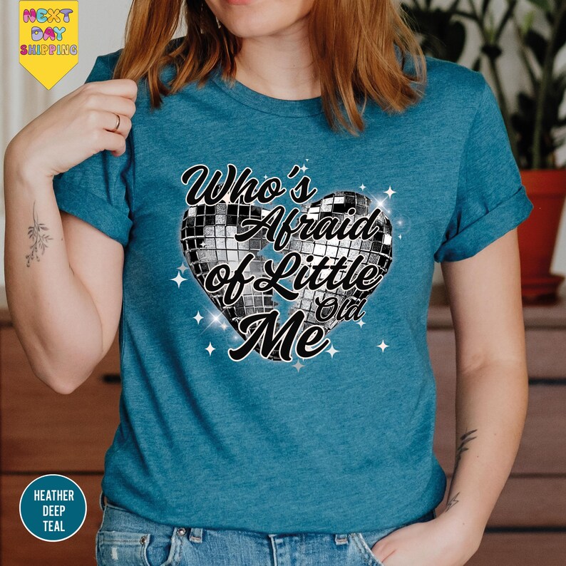 a woman wearing a blue t - shirt with a heart on it