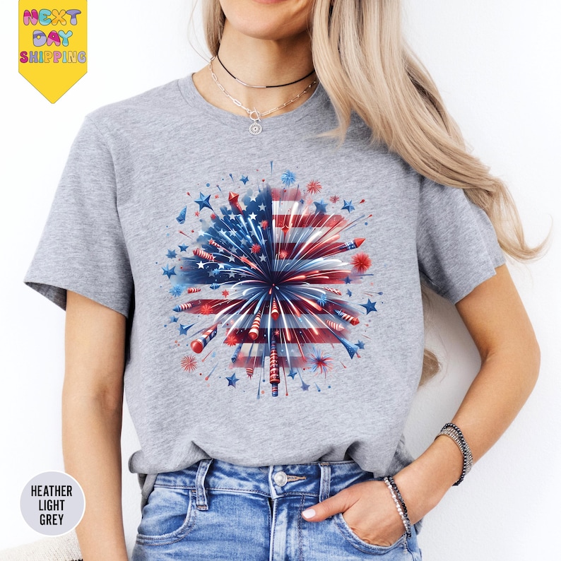a woman wearing a t - shirt with a fireworks design on it