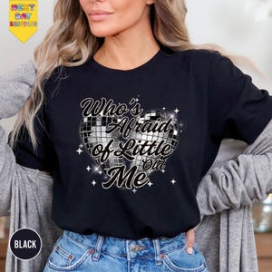 a woman wearing a black t - shirt with the words who's afraid of