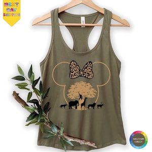 May include: Olive green tank top with a Minnie Mouse silhouette design. The design features a leopard print bow, a tree, and silhouettes of animals. The words "NEXT DAY SHIPPING" are in a yellow banner in the upper left corner.