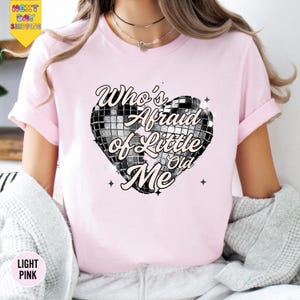 a woman wearing a pink shirt with a heart on it