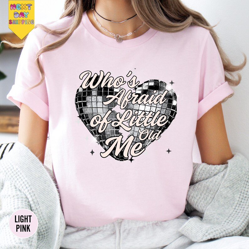 a woman wearing a pink shirt with a heart on it