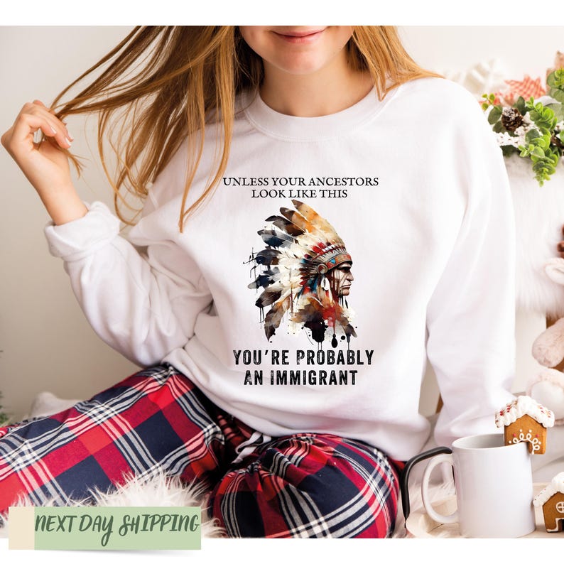 a woman wearing a white sweatshirt with an indian headdress