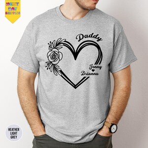 A man wearing a grey t-shirt with a heart design and text that says "Paddy Jenny Brianna".