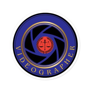 May include: A blue and gold circular sticker with the word "Videographer" around the edge. Inside the circle is a black and white camera lens with a red circle in the centre. The red circle has a gold scale of justice with an arrow pointing upwards.