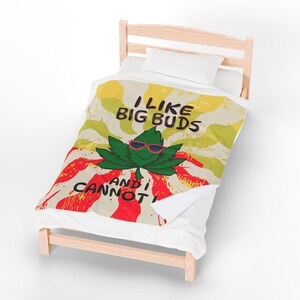 May include: A twin-sized bed with a light wood frame and white bedding. The comforter features a green cannabis leaf wearing sunglasses with the text "I LIKE BIG BUDS AND I CANNOT". The background has red, yellow, and white stripes.