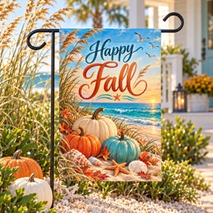 May include: A rectangular garden flag featuring the text Happy Fall in blue and orange script. The scene depicts a beach with white, orange, and teal pumpkins, seashells, and a starfish on the sand, with a blue ocean and sky in the background.