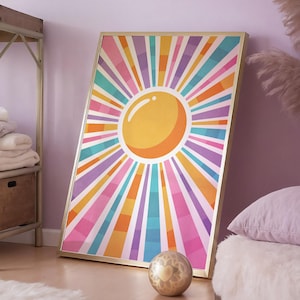May include: A colourful abstract sunburst print with a yellow sun in the centre. The print is framed in a gold frame and is hanging on a light purple wall.