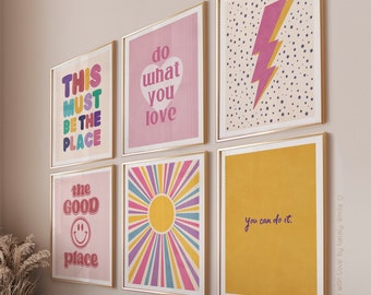 May include: Set of six colorful wall art prints with motivational quotes and retro designs. The prints feature a pink background with rainbow text, a yellow sun with rainbow rays, a pink lightning bolt on a white background with black polka dots, a pink background with a smiley face and the text "the good place", a pink background with the text "do what you love", and a yellow background with the text "you can do it".