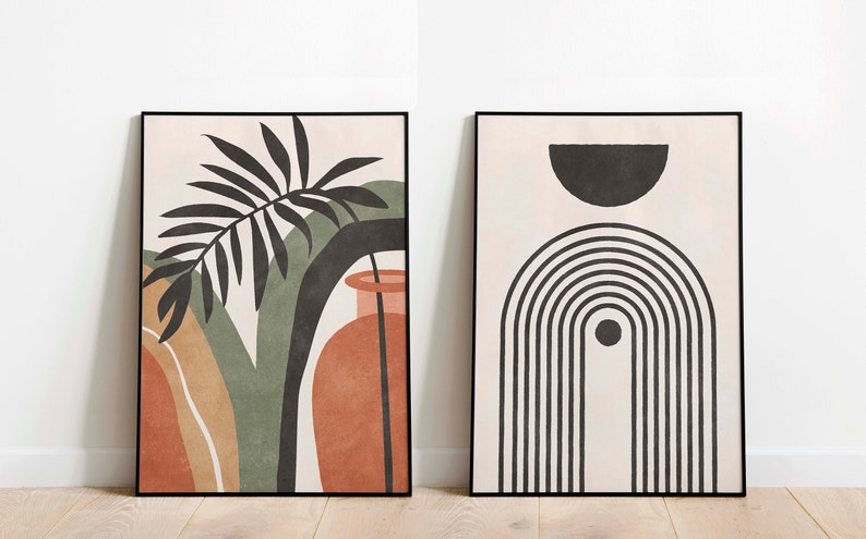 May include: Two framed abstract art prints in a minimalist style. The print on the left features a black and green palm leaf with a terracotta vase. The print on the right features a black and white geometric design with a half circle and a rainbow.