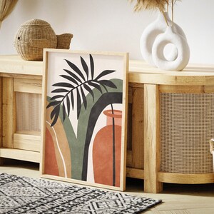 May include: A wooden cabinet with a woven rattan front and a large abstract art print featuring a green palm leaf and a red vase. The cabinet is decorated with a wicker basket and a white ceramic vase with a circular cutout.