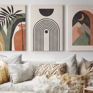 May include: Three abstract art prints with a minimalist design. The first print features a green and brown leaf with a vase. The second print features a black and white geometric design. The third print features a brown arch with a crescent moon and green mountains.