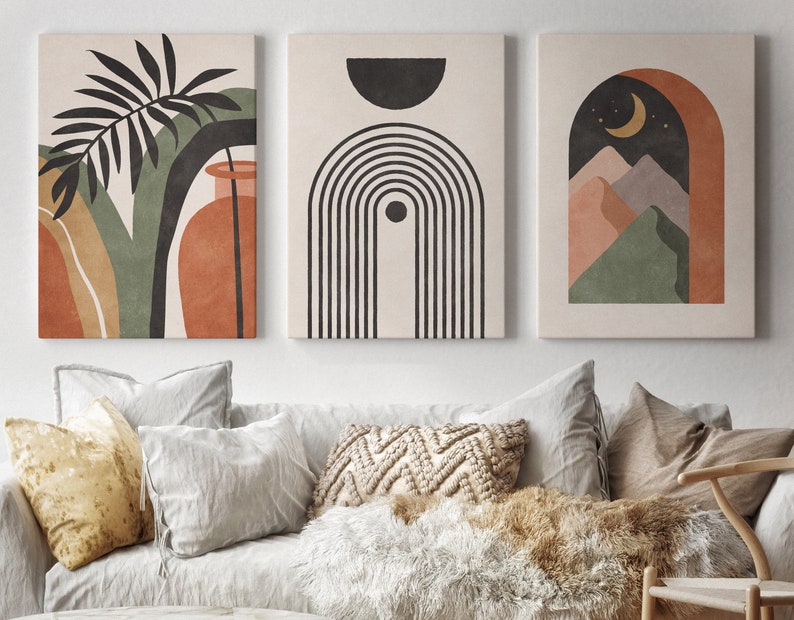 May include: Three abstract art prints with a minimalist design. The first print features a green and brown leaf with a vase. The second print features a black and white geometric design. The third print features a brown arch with a crescent moon and green mountains.