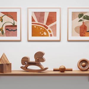K&ouml;nnte beinhalten: Drei gerahmte abstrakte Kunstdrucke mit einem braunen Holzrahmen, die eine Topfpflanze, eine Sonne und eine Vase mit einer Pflanze zeigen. Ein Holzregal mit einem Schaukelpferd, einem Holzhaus und einem Holzspielzeug mit einer Kugel an einer Schnur.