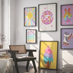 May include: A collection of seven framed prints with a retro 70s theme. The prints feature a sunburst, a disco ball, a peace sign, roller skates, and the word "girls" repeated five times. The prints are all in bright colors and have black frames.