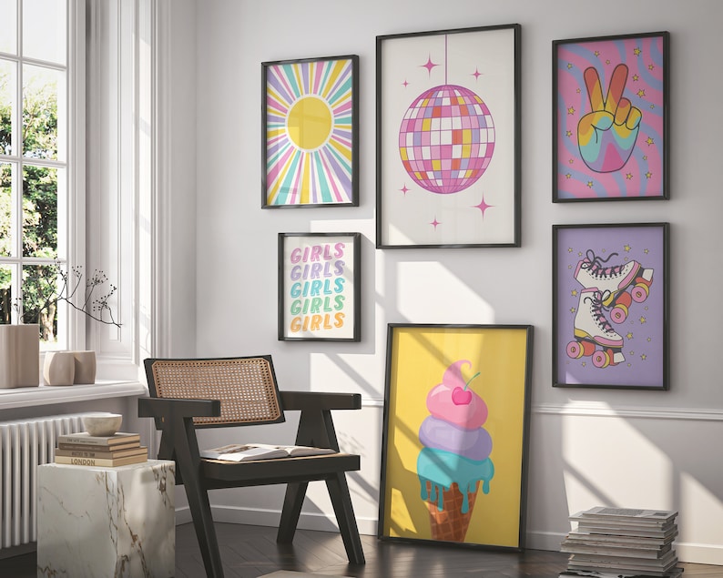 May include: A collection of seven framed prints with a retro 70s theme. The prints feature a sunburst, a disco ball, a peace sign, roller skates, and the word "girls" repeated five times. The prints are all in bright colors and have black frames.