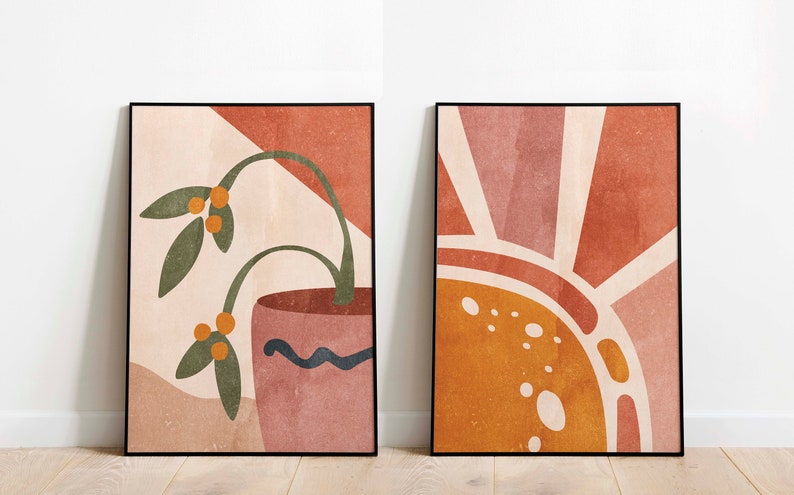 K&ouml;nnte beinhalten: Zwei abstrakte Kunstdrucke im minimalistischen Stil. Der Druck auf der linken Seite zeigt eine gr&uuml;ne Pflanze mit orangefarbenen Beeren in einem rosafarbenen Topf vor einem pfirsichfarbenen Hintergrund. Der Druck auf der rechten Seite zeigt eine stilisierte Sonne in den Farben Orange, Pfirsich und Wei&szlig; vor einem pfirsichfarbenen Hintergrund.