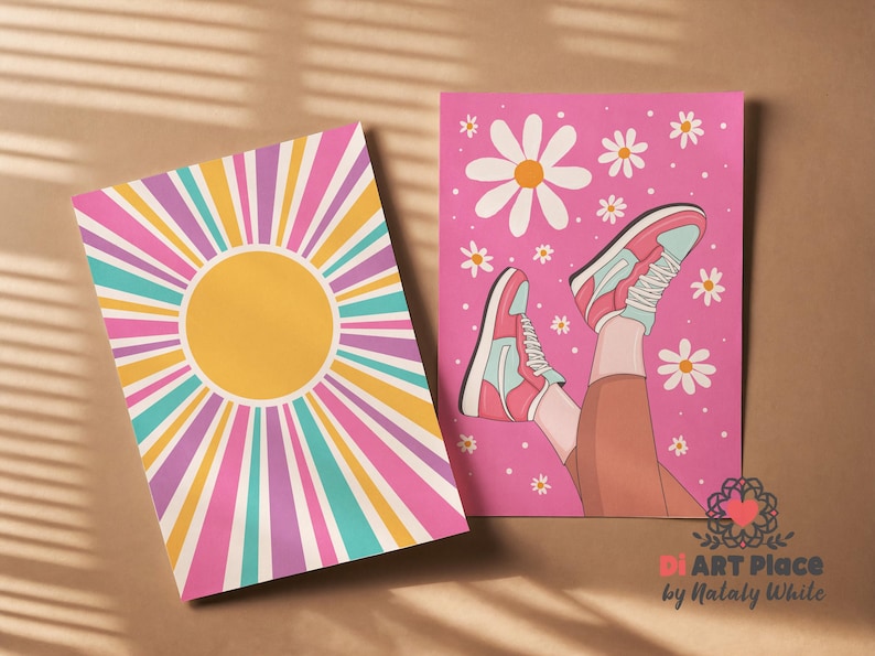 May include: Two art prints. One features a yellow sunburst design with pink, purple, teal, and yellow rays. The other print is pink with a drawing of legs wearing pink and teal sneakers, surrounded by white daisies.