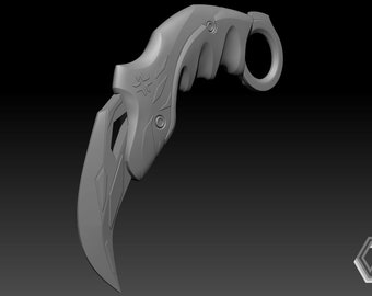 May include: A silver-colored metal knife with a curved blade and a finger ring. The knife has a textured handle and a decorative design on the blade.