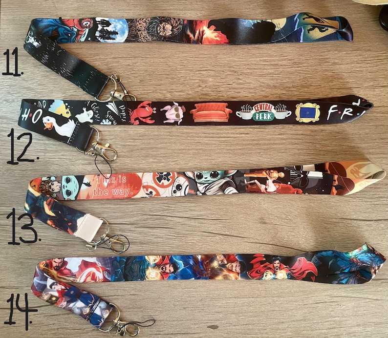 May include: Ten colorful lanyards with different designs, including a Stranger Things design, a Friends design, a Baby Yoda design, and a Marvel design. The lanyards are numbered 11 through 14.