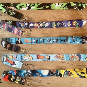 May include: A set of ten colorful lanyards with various cartoon and movie character designs. The lanyards are made of a soft, durable material and feature a variety of colors, including blue, green, yellow, and black. The lanyards are perfect for holding keys, ID badges, or other small items.