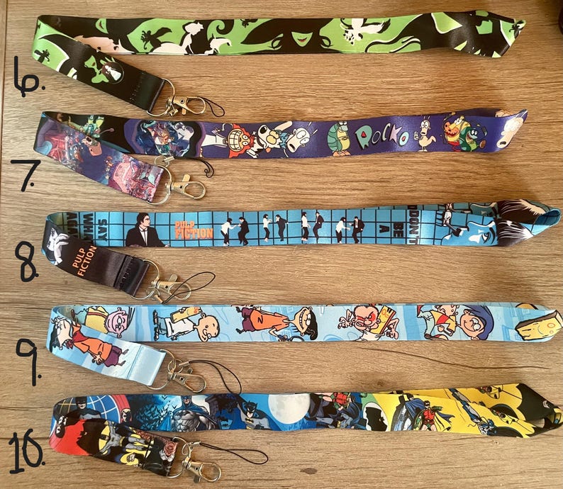 May include: A set of ten colorful lanyards with various cartoon and movie character designs. The lanyards are made of a soft, durable material and feature a variety of colors, including blue, green, yellow, and black. The lanyards are perfect for holding keys, ID badges, or other small items.