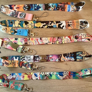 May include: Five colorful lanyards with cartoon characters printed on them. The lanyards are numbered 1 through 5. The characters include Dexter's Laboratory, Johnny Bravo, Courage the Cowardly Dog, and the Powerpuff Girls.