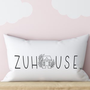 以下が含まれることがあります： 「ZUHAUSE」という黒い文字と小さな家のイラストが書かれた白い枕