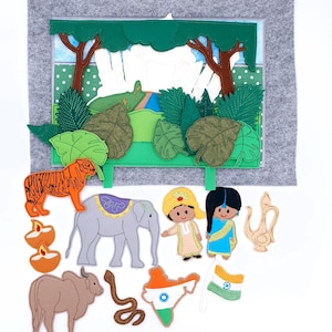 Puede incluir: Un juego de fieltro que representa una escena de la jungla con un tigre, un elefante y otras figuras de temática india. El juego incluye un telón de fondo de fieltro con árboles y un río, y varios recortes de fieltro.