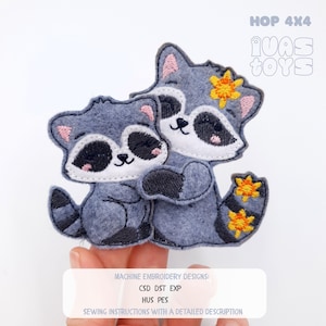 May include: Two grey raccoon machine embroidery designs, one embracing the other. The raccoons have black masks, white faces, and pink accents. The larger raccoon has yellow flower accents. Text at the top reads "HOP 4X4" and "IUAS TOYS". Below, text reads "MACHINE EMBROIDERY DESIGNS: CSD DST EXP HUS PES SEWING INSTRUCTIONS WITH A DETAILED DESCRIPTION."