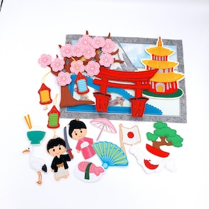 May include: A collection of felt Japanese-themed decorations, including a cherry blossom tree, a red torii gate, a pagoda, and various cultural icons. The set features a crane, sushi, a fan, and figures in traditional attire.