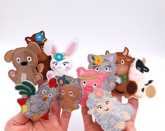 May include: A selection of felt finger puppets depicting farm animals. The puppets include a brown dog, a white rabbit, a grey cat, a brown cow, a black and white cow, a grey rooster, a brown owl, a pink pig, and a grey sheep, each with floral details.