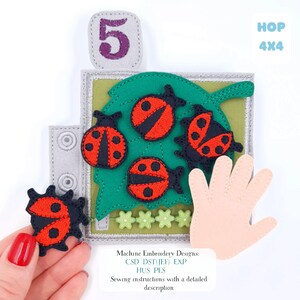 May include: A felt educational toy with a green leaf holding four red and black ladybugs, a grey number 5, and a hand shape. The text "HOP 4X4" is visible. The toy includes sewing instructions.