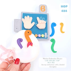 May include: A felt educational toy with a blue background featuring hand shapes and the number 6. Colourful felt dinosaurs are scattered around an egg-shaped object. The text "HOP 4X4" is visible.