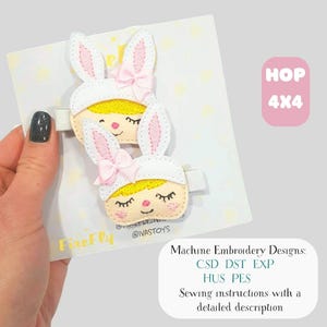 May include: Two white and pink bunny hair clips with embroidered faces and pink bows. The clips are on a white card with a light yellow polka dot pattern. The text "HOP 4x4" is in a pink box. The text "FireFly" and "@IVASTOYS" are also visible.