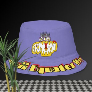 May include: A lilac bucket hat with a graphic design. The design features the text "Equates Grimmi" in yellow and red, with a crown above the text. The brim of the hat has the text "Equates Why" in yellow and red.
