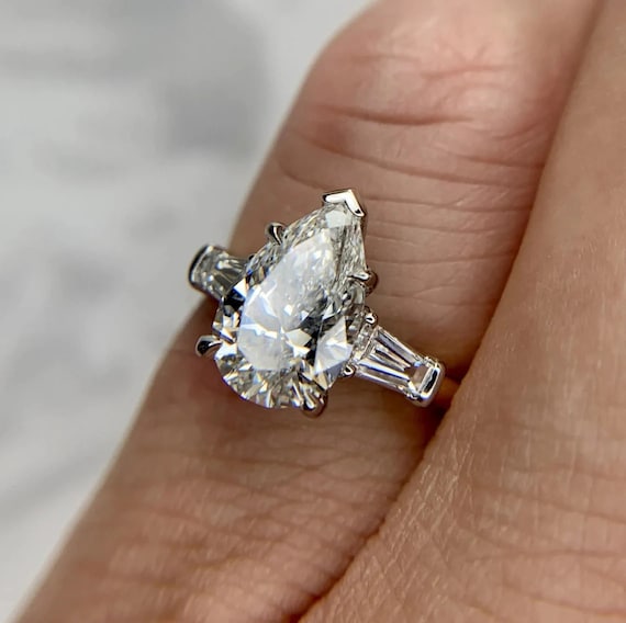 From The Alson Signature Collection A Platinum Engagment Ring, Set With A  Pear Shape Diamond That Weighs 3.38 Cts, GIA Certifed SI1-F, 2 Tapered  Baguettes .50 c… | Engagement rings, Pear shaped