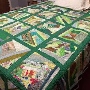 May include: A patchwork quilt featuring a grid of square blocks separated by solid green fabric sashing. Each block contains various fabric scraps in shades of green, yellow, and white, with some blocks displaying small printed patterns and motifs.