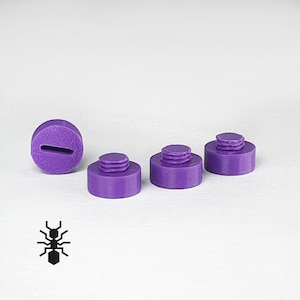 May include: Four purple plastic caps with a threaded top. The caps are different sizes and are arranged in a row.