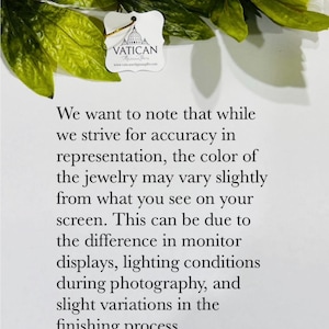 May include: A white tag with the word "VATICAN" and a logo is shown, along with text explaining that the jewelry color may vary slightly from the screen. Green leaves and yellow flowers are in the background.